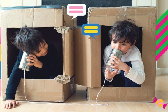 Zwei Kinder spielen in Kartons