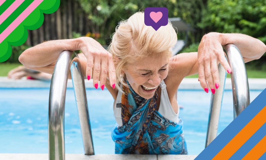 Ältere Dame stützt sich lachend am Pooltreppengeländer